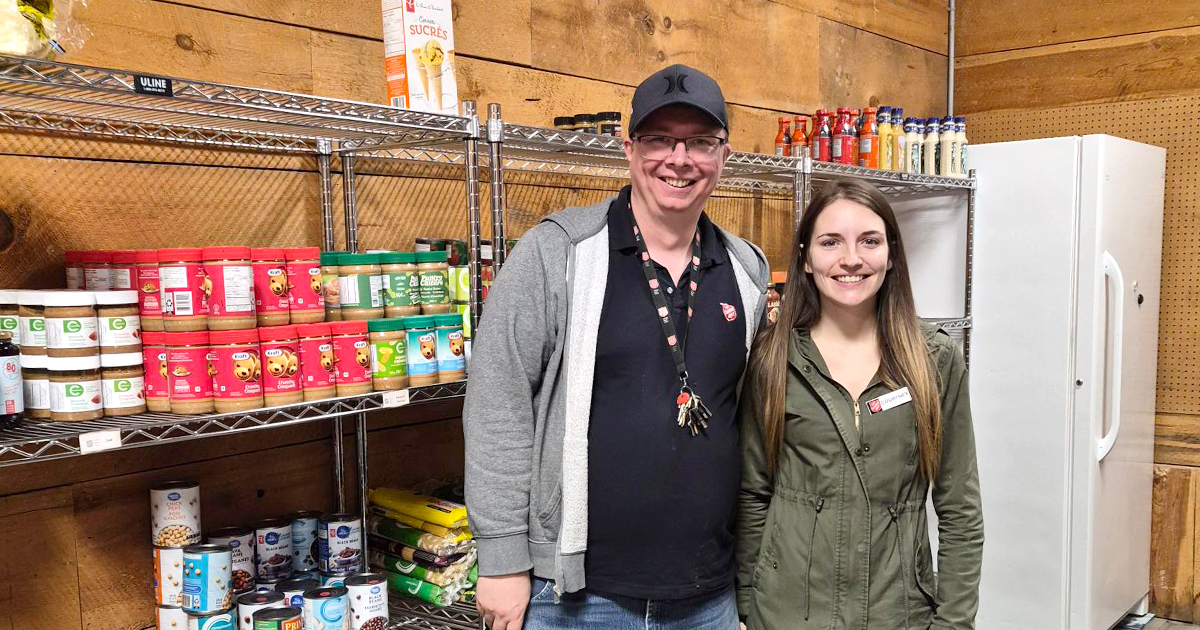Two people standing next to shelves of food